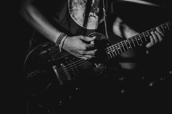 Närbild på gitarrspelande hand